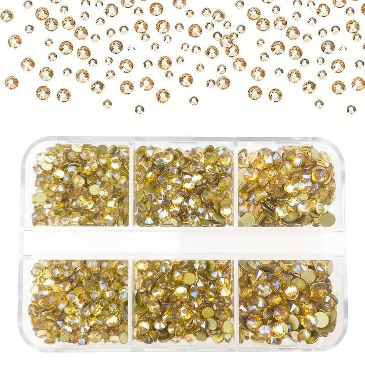 Gold nail art rhinestones set — mixed sizes in clear compartment tray with scattered crystals — NSI Australia