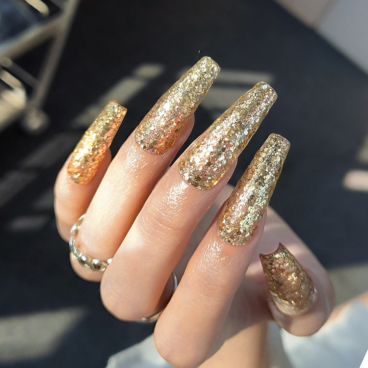 Nail Success Australia gel polish C059 in a champagne gold glitter, shown on a model's long glossy coffin nails