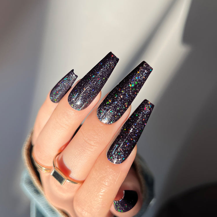 Nail Success Australia gel polish C063 in a black base with multicolour holographic glitter, shown on a model's long glossy coffin nails
