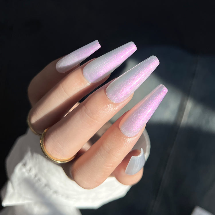 Nail Success Australia gel polish C067 in a pearl white with pink and purple aurora shimmer, shown on a model's long glossy coffin nails