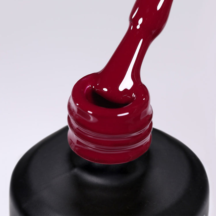 Nail Success Australia gel polish C071 in a deep wine red, a close-up of the brush lifting from the bottle neck showing the creamy colour