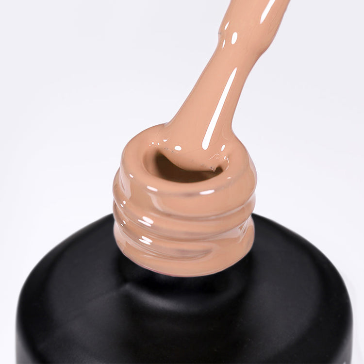 Nail Success Australia gel polish C076 in a nude beige, a close-up of the brush lifting from the bottle neck showing the creamy colour