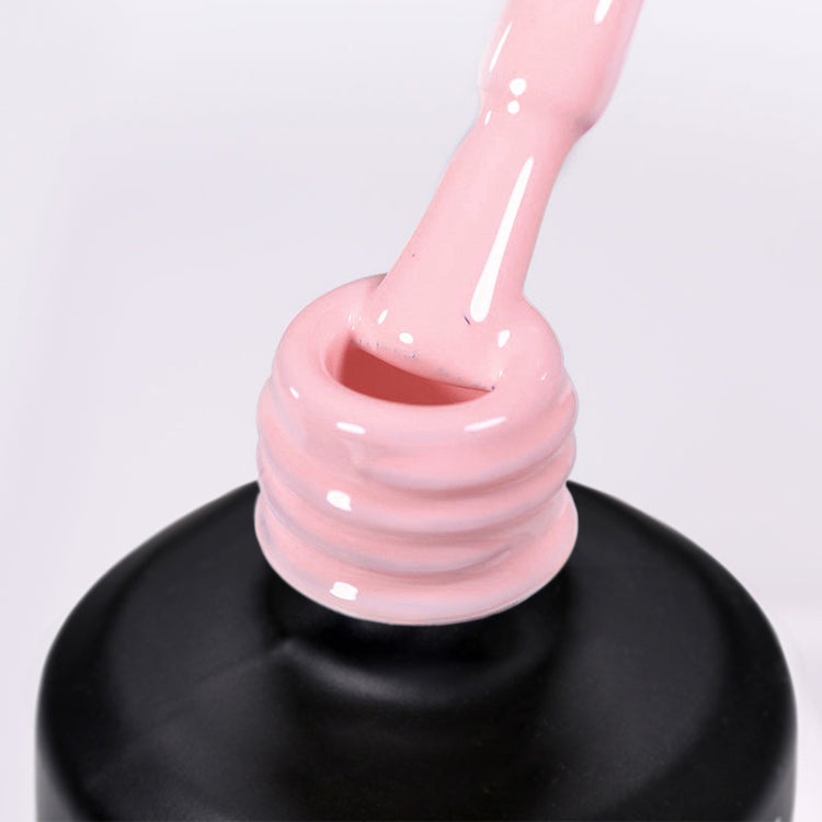 Nail Success Australia gel polish C083 in a soft pale pink, a close-up of the brush lifting from the bottle neck showing the creamy colour