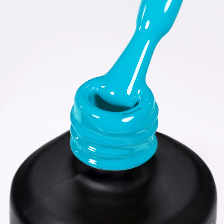 Nail Success Australia gel polish C092 in a bright sky blue, a close-up of the brush lifting from the bottle neck showing the creamy colour