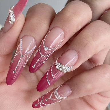 Silver caviar bead nail art with pink ombre stiletto nails, rhinestone accents and draped chain detail design