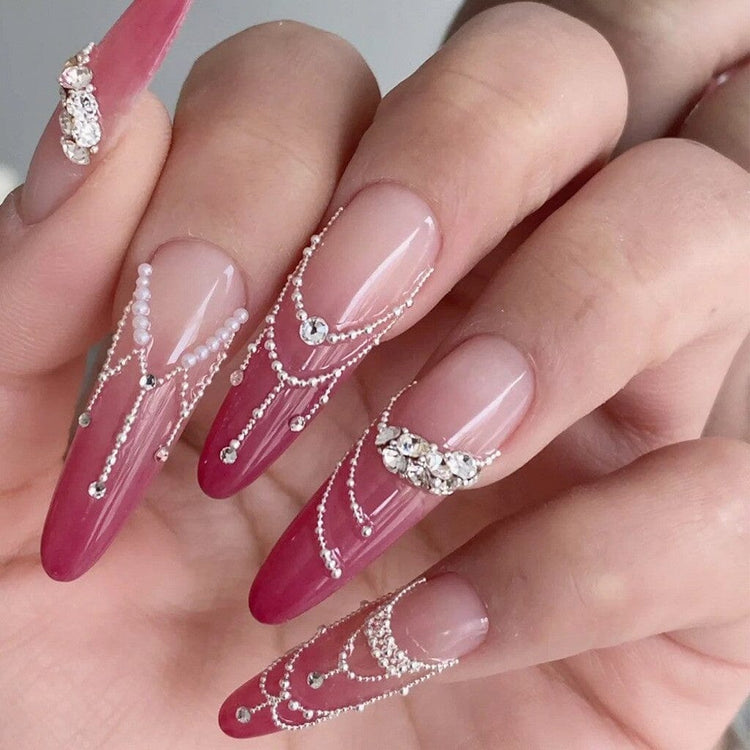 Silver caviar bead nail art with pink ombre stiletto nails, rhinestone accents and draped chain detail design
