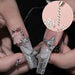 Silver caviar bead nail art with glitter French tips, butterfly charms and rhinestone manicure design sample