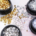 NSI Australia nail art mix — gold metal beads, silver dome studs, white half pearls and clear rhinestones in mixed sizes, spilling from jars