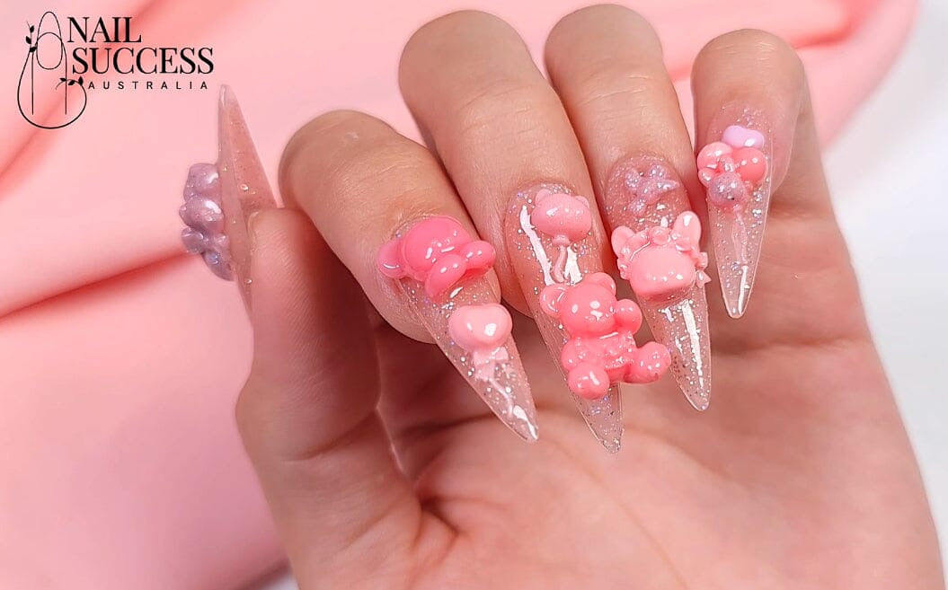 Clear stiletto nails with pink 3D gummy-bear gel accents and glitter — Nail Success Australia