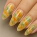NSI Blooming Gel marble nail art — glossy almond nails in yellow, orange and green smoke effect, close-up on hand