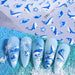 Nail Success Australia SWO-101 blue whale nail art stickers shown on light blue ocean-themed sample nails with waves, starfish and whale designs