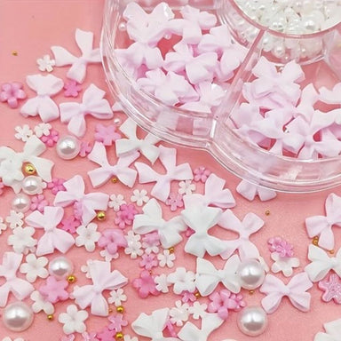 white bows, daisy shapes, pearls and gold beads spilled from wheel for DIY gel or acrylic nails