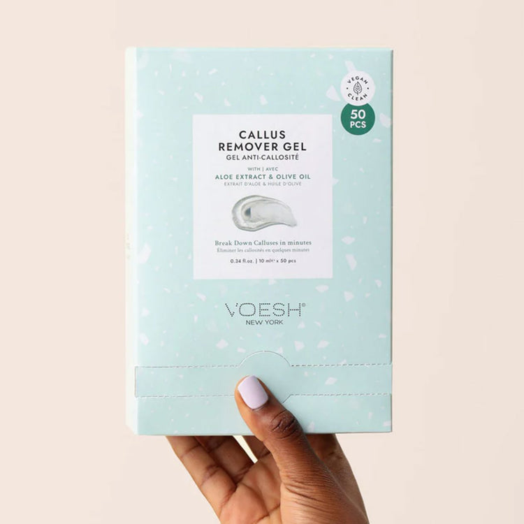 Hand holding VOESH New York Callus Remover Gel box, 50-piece sachet pack with aloe extract and olive oil