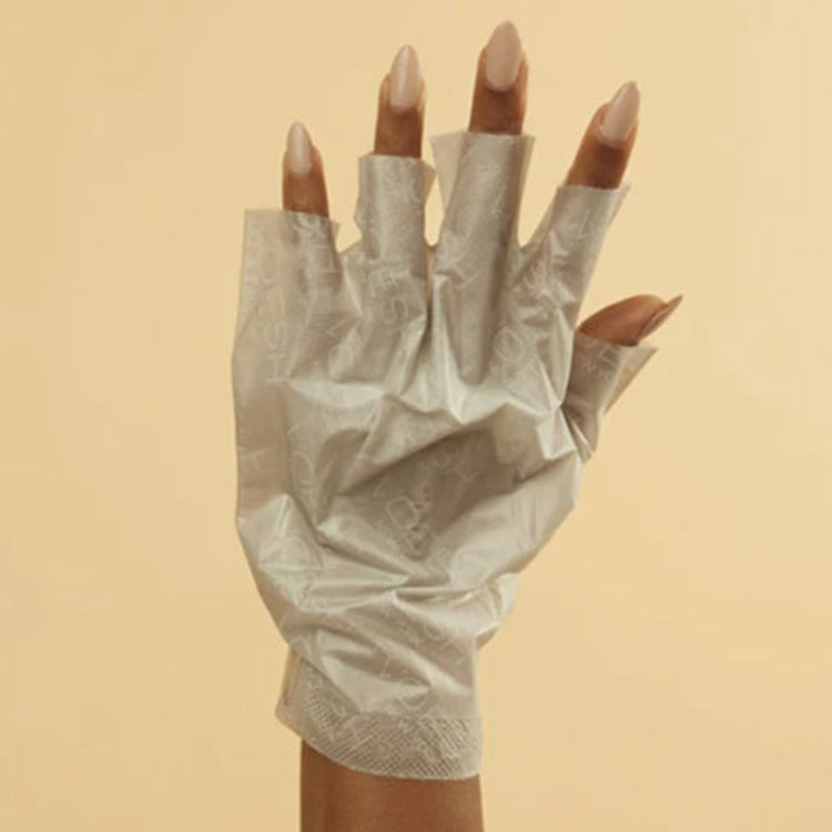 Hand wearing Voesh collagen glove hand mask with argan oil and floral extracts