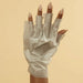 Hand wearing Voesh collagen glove hand mask with argan oil and floral extracts