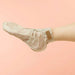 Foot wearing Voesh collagen treatment sock with argan oil and floral extracts