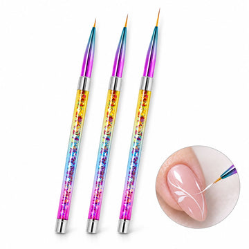Three nail art liner brushes with multicoloured handles and rainbow ferrules, shown painting white leaf designs on a nude pink nail.
