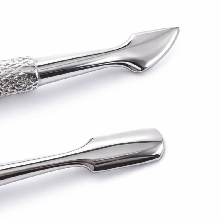 Close-up of a stainless steel cuticle pusher showing the angled pusher end and flat scraper end