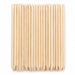 Bundle of wooden cuticle pusher sticks with pointed tips and large angled flat ends arranged on a white background