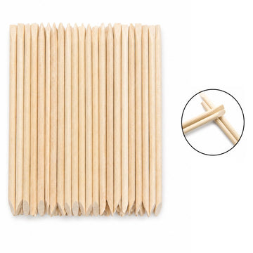 Wooden cuticle pusher sticks with large angled flat ends and pointed tips, shown in a clear hanging plastic bag