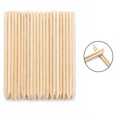 Wooden cuticle pusher sticks with large angled flat ends and pointed tips, shown in a clear hanging plastic bag