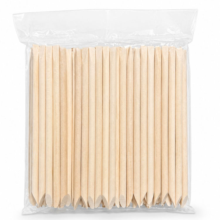 Pack of wooden cuticle pusher sticks with large angled flat ends and pointed tips in clear plastic bag packaging