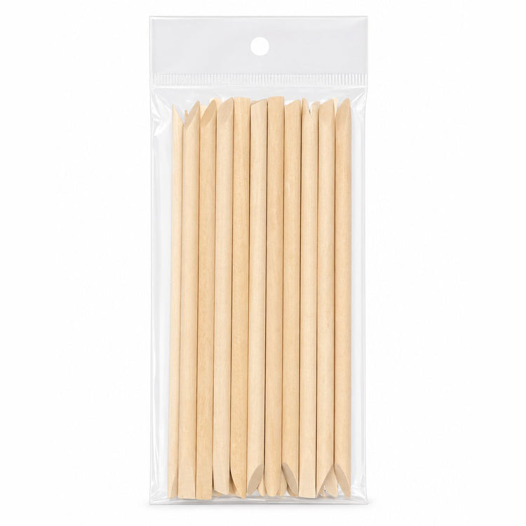 Pack of wooden cuticle pusher sticks with large angled flat ends and pointed tips in clear hanging plastic bag packaging