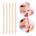 Five wooden cuticle pusher sticks shown upright with two close-up photos demonstrating cuticle care use on natural nails