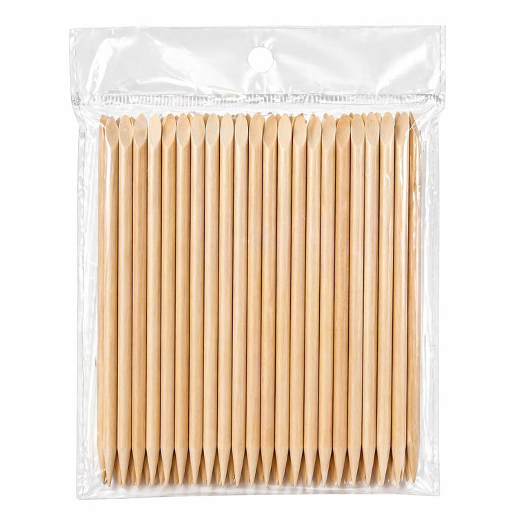 Bulk pack of wooden cuticle pusher sticks in a clear hanging plastic bag on a light gray background
