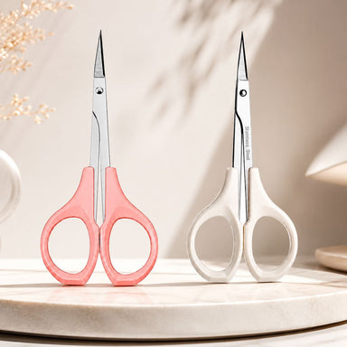 Pink and white handle cuticle scissors set with stainless steel precision blades displayed on salon tabletop for manicure trimming and nail care