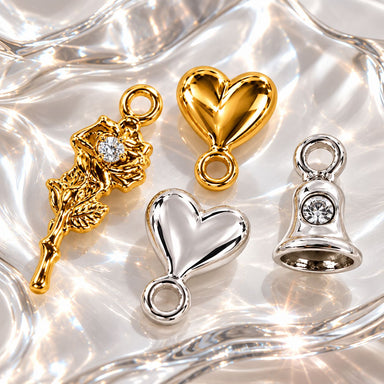 Gold and silver dangle nail charms, including a rhinestone rose, hearts and a bell