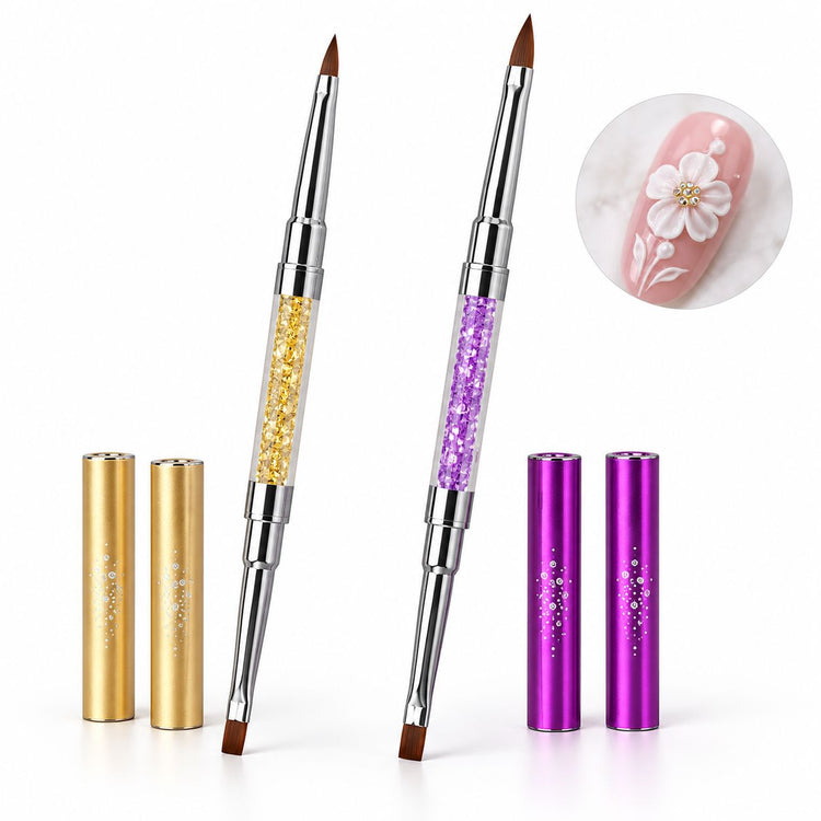 Gold and purple double-ended nail art brushes with crystal-filled handles, pointed and flat tips and matching caps, shown with white 3D floral nail art.
