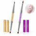 Gold and purple double-ended nail art brushes with crystal-filled handles, pointed and flat tips and matching caps, shown with white 3D floral nail art.
