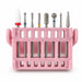 Eight-piece ceramic and diamond nail drill bit set with assorted cone, ball and cylinder shapes in a pink storage stand.
