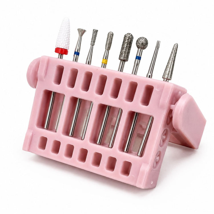 Eight-piece ceramic and diamond nail drill bit set in assorted shapes, displayed in an angled pink storage stand.
