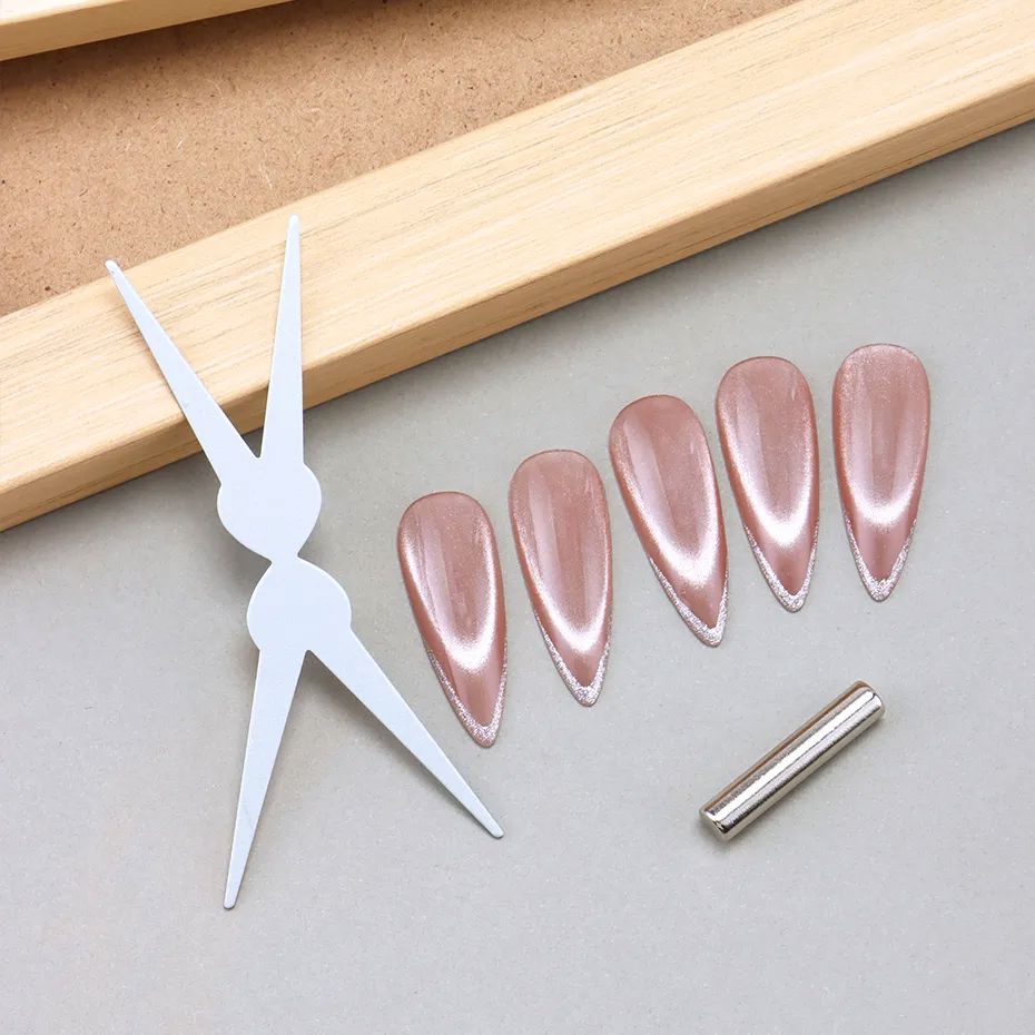 White double-ended scissor-style cat eye magnet tool set shown with five pink magnetic cat-eye nail tips and a silver bar magnet.