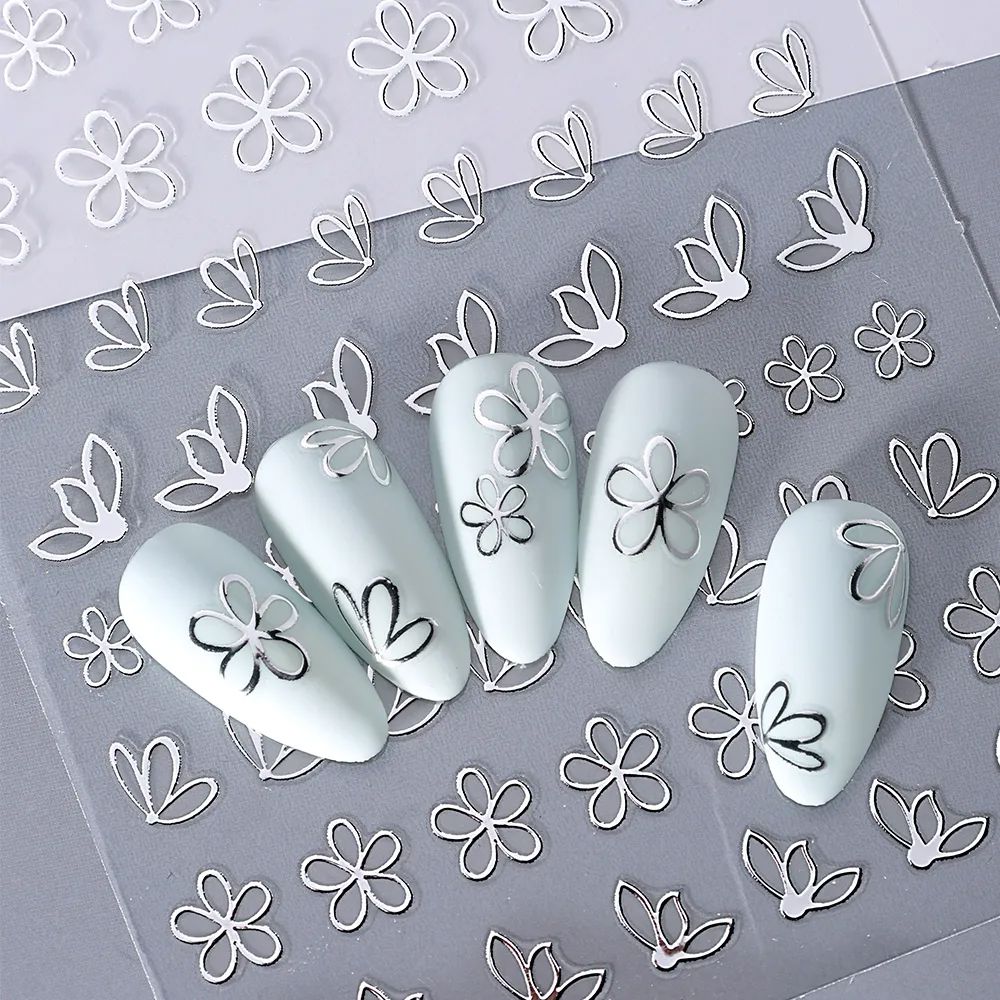 Silver flower outline nail art stickers with floral petal decals shown on light blue manicure