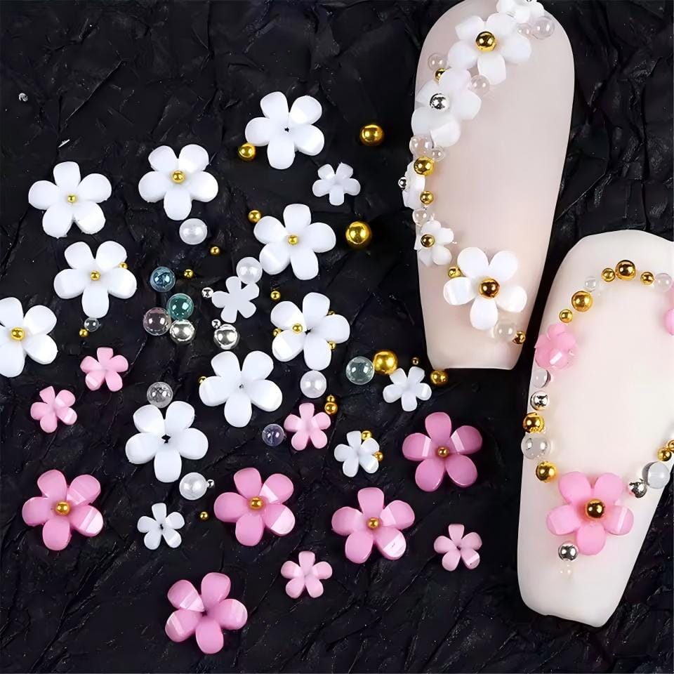 White & pink 3D flower nail art charms — mixed-size daisies with pearls and gold beads, shown on nude tips for DIY gel or acrylic nails
