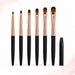 Six gel nail brushes in assorted sizes with black handles, rose gold ferrules and oval brown bristles, displayed beside a black protective cap.
