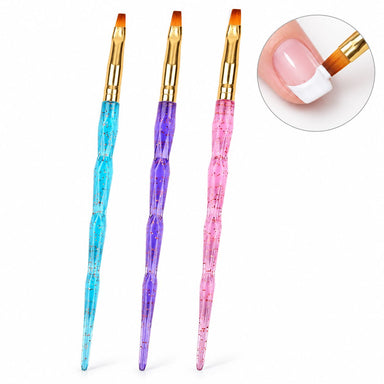 Three flat gel nail brushes with blue, purple and pink glitter handles and gold ferrules, shown painting a white French tip.
