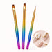 Three gel design brushes with multicolour handles and oval, square and liner tips, shown with white floral and gold line nail art.
