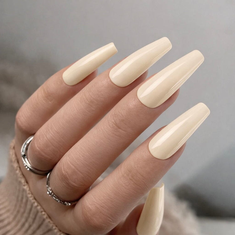 Creamy pale nude-yellow gel polish swatch on long coffin nails