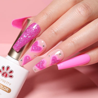 Hot pink gel manicure with glitter heart nail art and rhinestones, long coffin nails holding Born Pretty Gel Color
