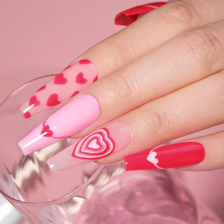 Pink heart nail art on long coffin nails—jelly red tips, layered heart accent, glossy gel manicure