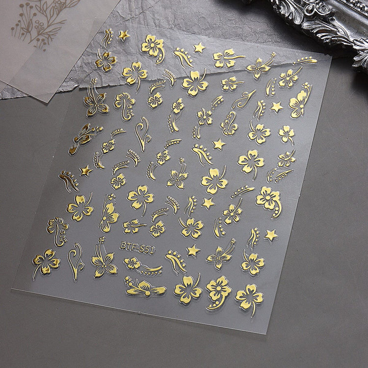 Nail Success Australia BTF-S51 gold hibiscus flower nail stickers with floral, star and swirl designs on grey background