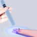 Blue USB rechargeable LED nail torch flash curing a gel tip with a rhinestone accent