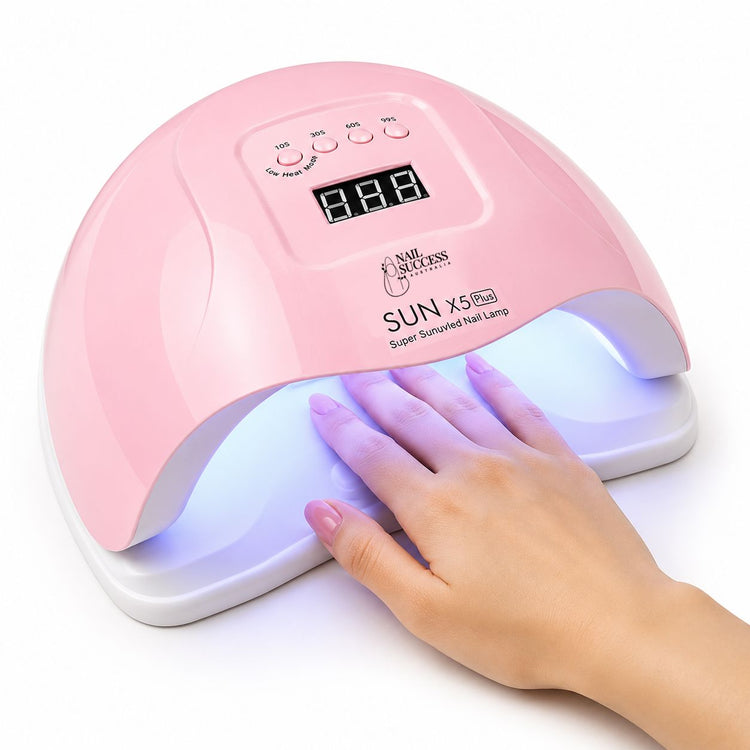 Pink 80W LED UV nail lamp with digital timer curing gel polish on a manicured hand