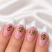 Gold script letter nail art charms on pink and white French tip almond nails