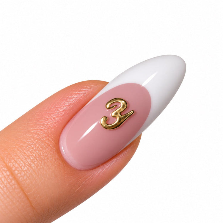Gold script letter Y nail art charm on a pink French tip almond nail