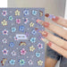 MO-383 Lily and Hibiscus Flower Nail Art Sticker sheet with blue, pink, yellow and white floral designs on manicure sample